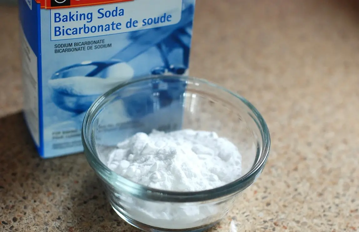 Bowl of baking soda beside a box of sodium bicarbonate used in a spider plant myth article